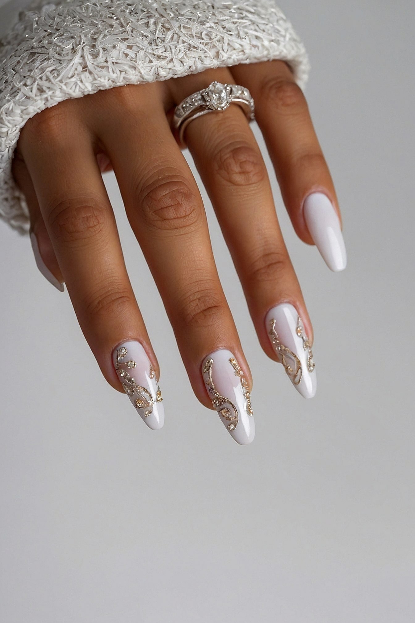 Almond nails with intricate gold and crystal accents