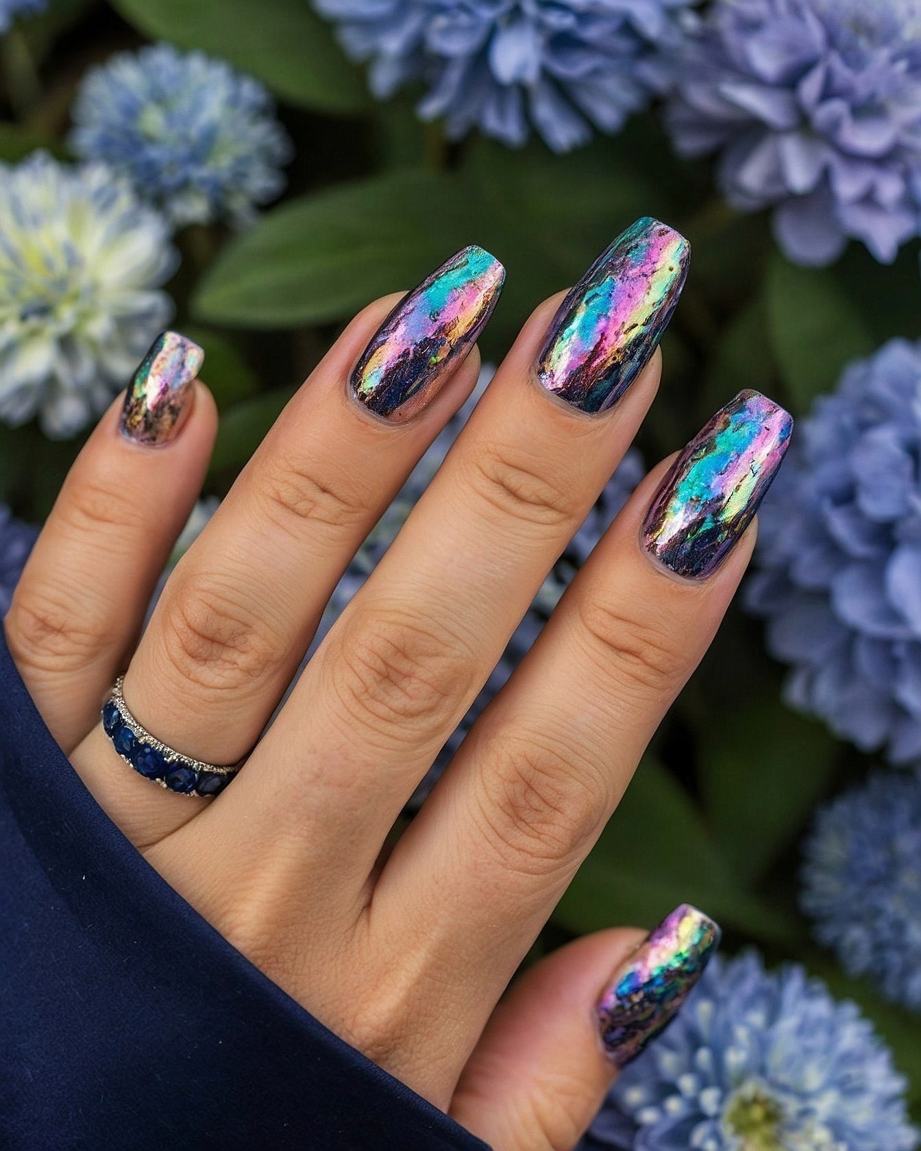 Close-up of Iridescent Chrome Nails Against Blue Florals