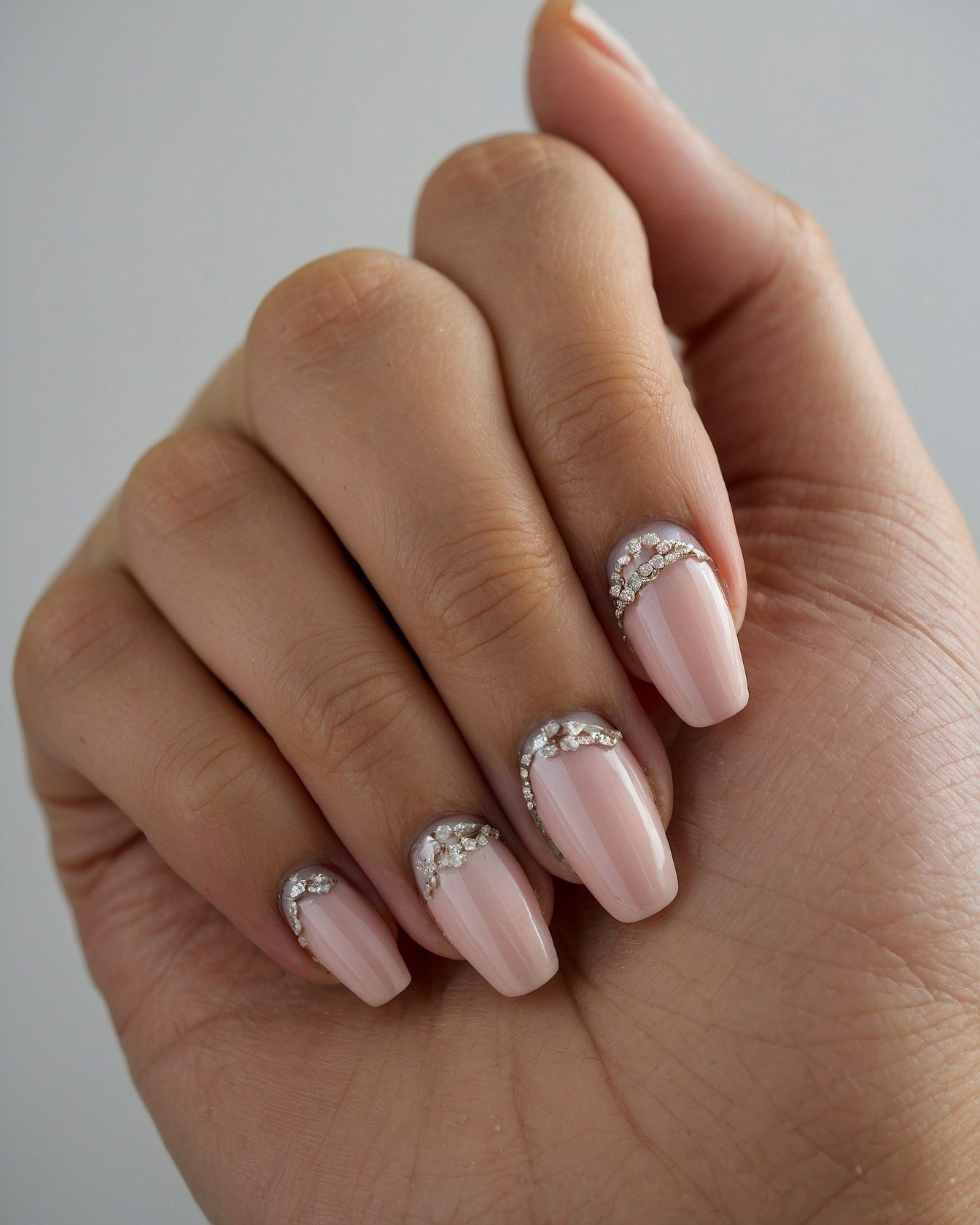 Close-up on Oval Nails with Metallic French Accents