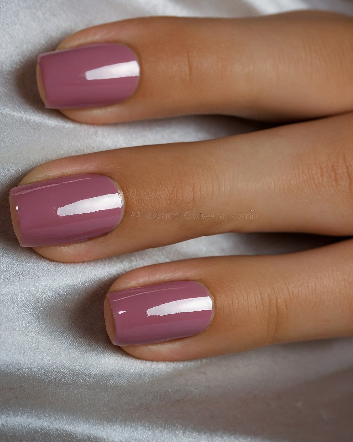 Close-up on Muted Mauve Nails Against Satin