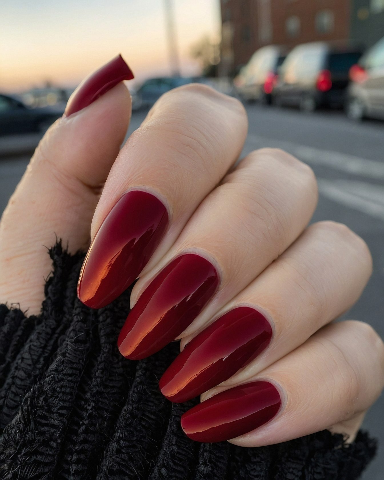 Glossy Deep Red Almonds Against Textured Black Knit