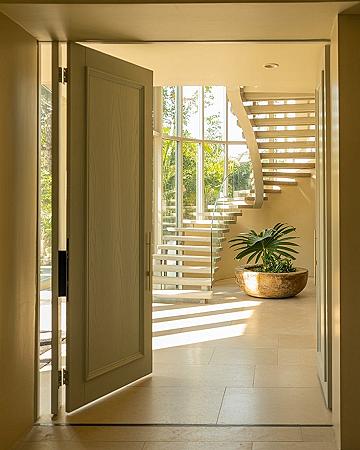 Dream Home Foyer: Open Stairs & Pivoting Door for a Grand Entrance