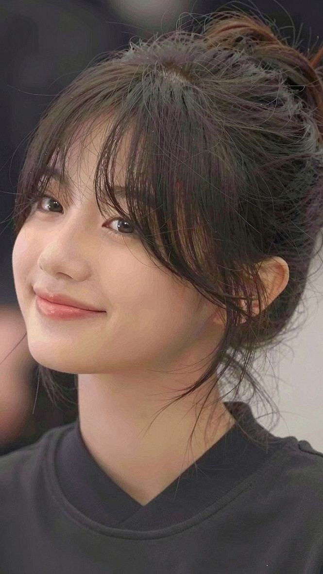 Why Wispy Bangs Create Balance For Round Faces