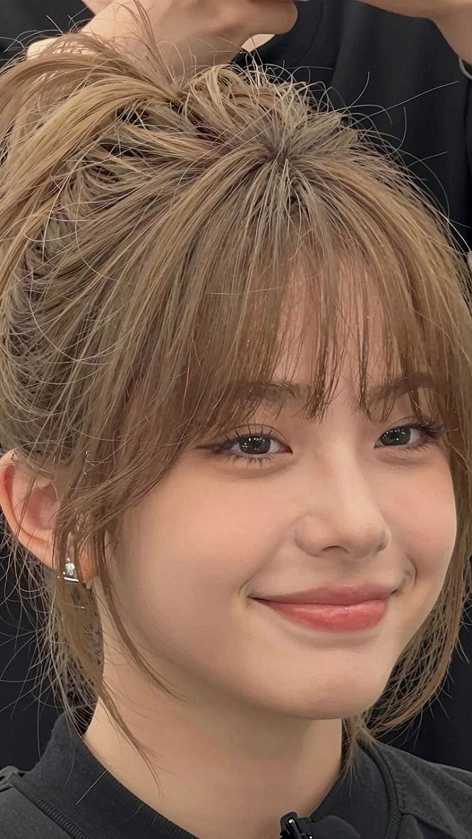 Choosing a Messy High Bun with Soft Curtain Bangs