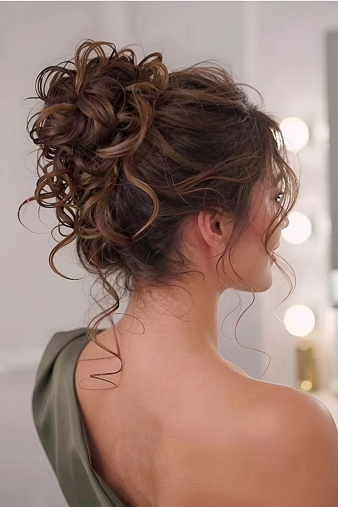 High Curly Bun With Loose Tendrils