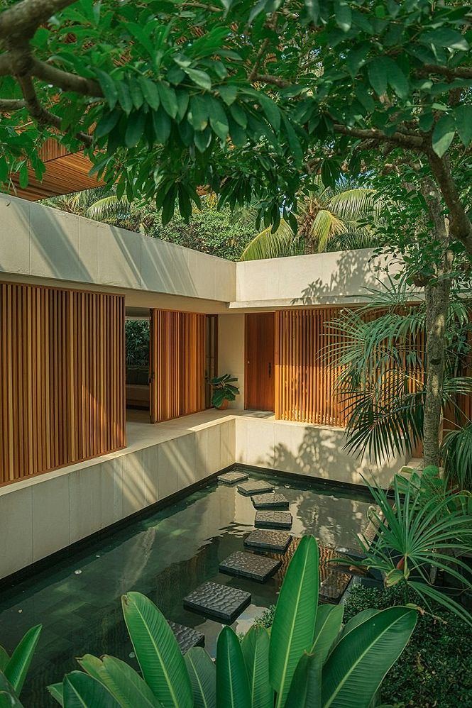 Modern Tropical House Exterior: Lush Gardens & Water Features