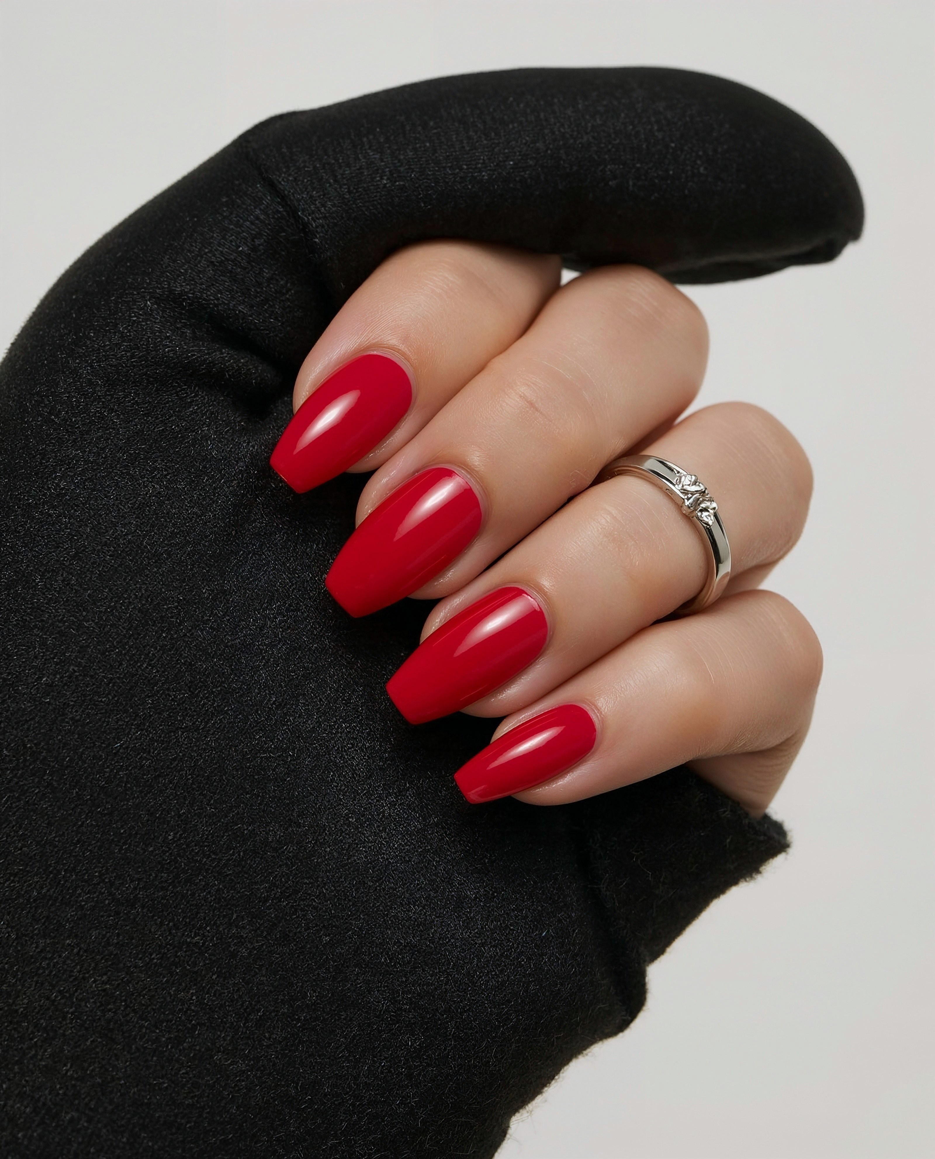 Close-up of crimson red nails and black fabric