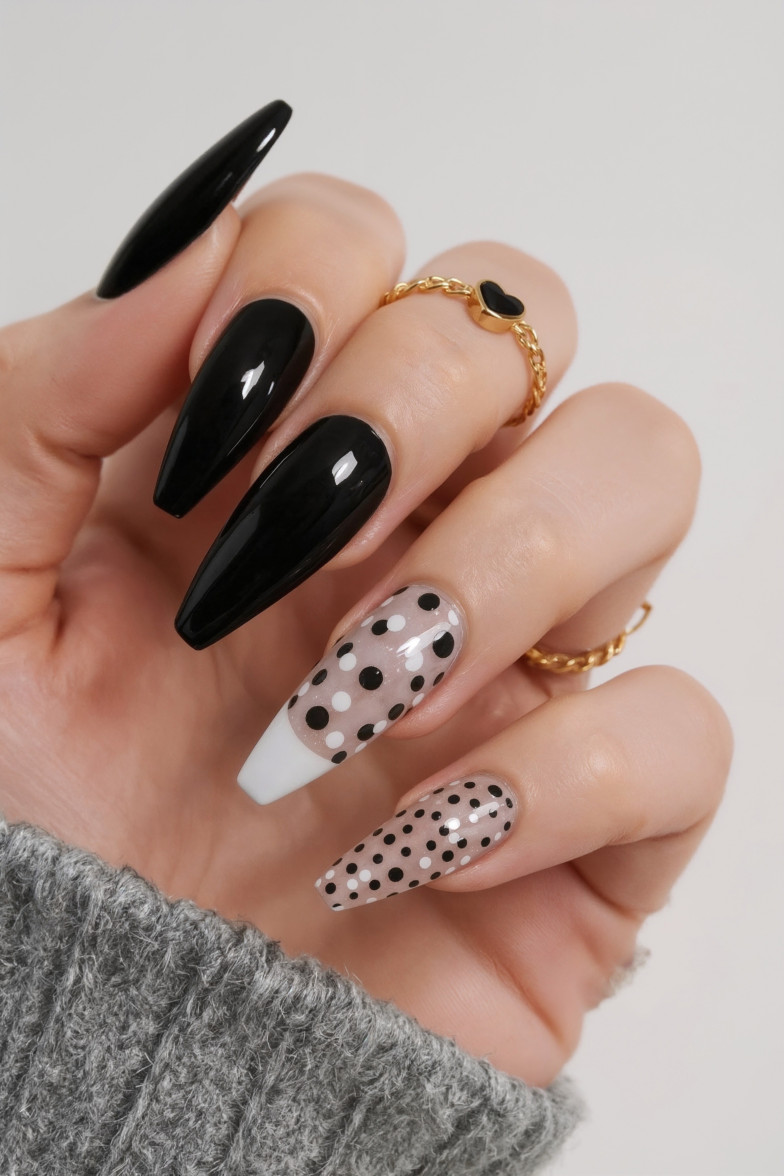 Glossy black and spotted nails with gold rings