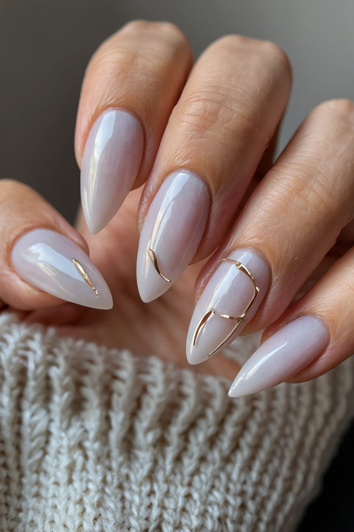 Close-up of Almond Nails with Gold Accents