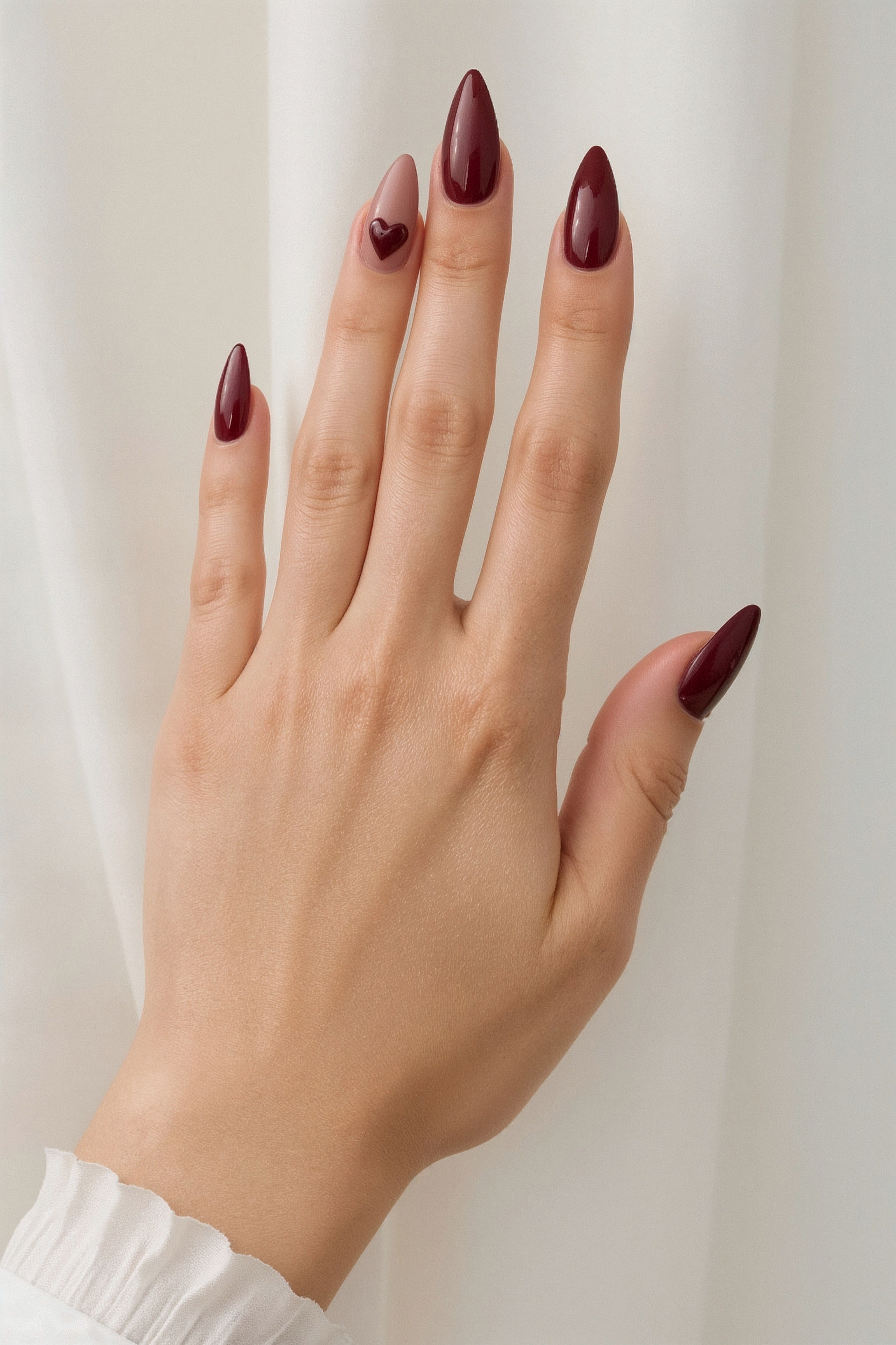 Burgundy stiletto nails with subtle heart accents