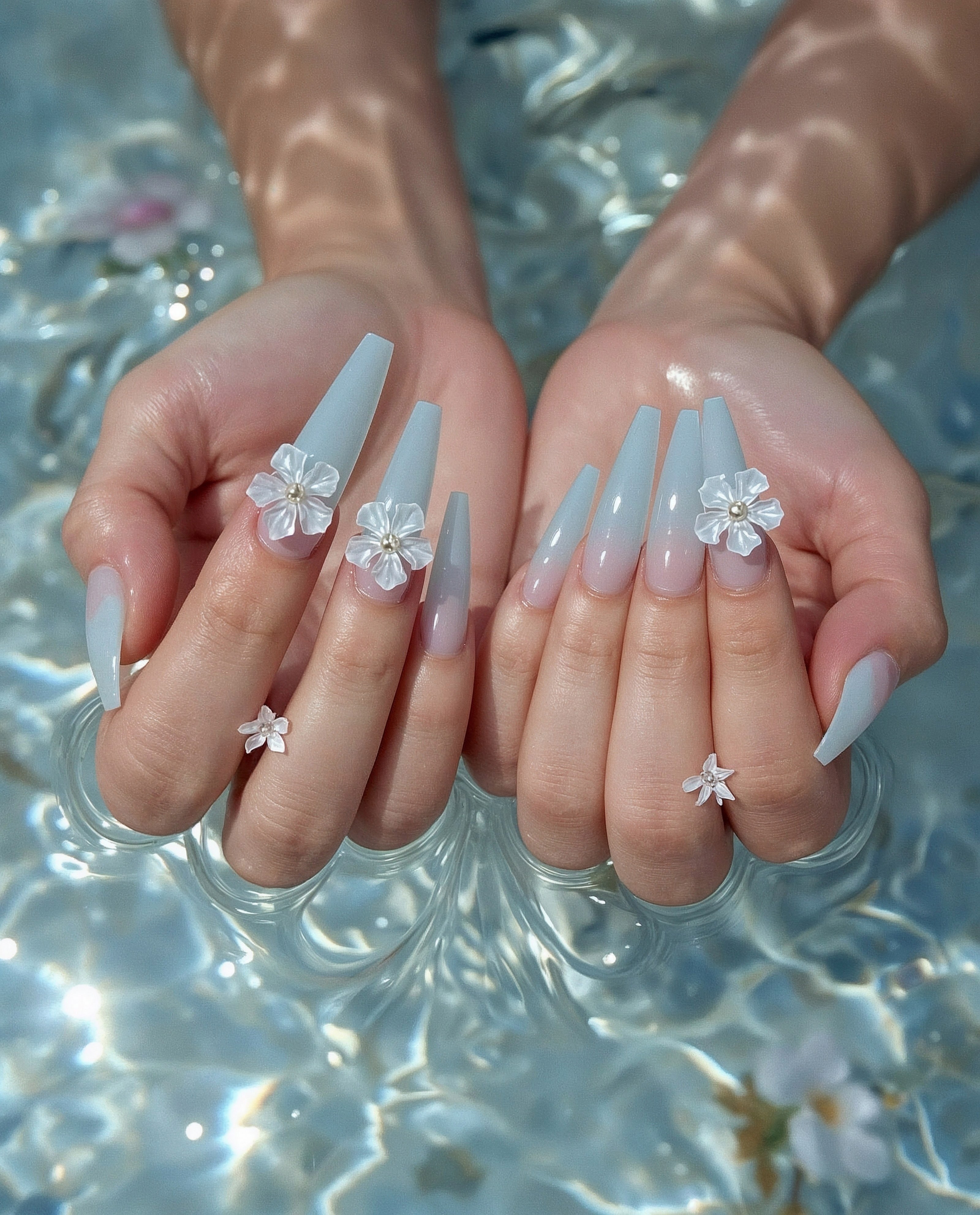 Hands submerged in rippling water with delicate nail art