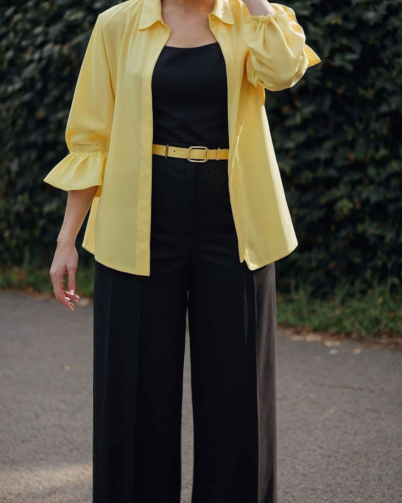 A pop of sunshine yellow layered with sophisticated black trousers