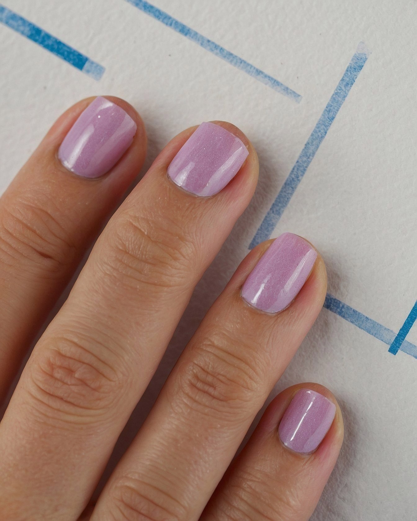 Close-up on lavender nails against graphic lines
