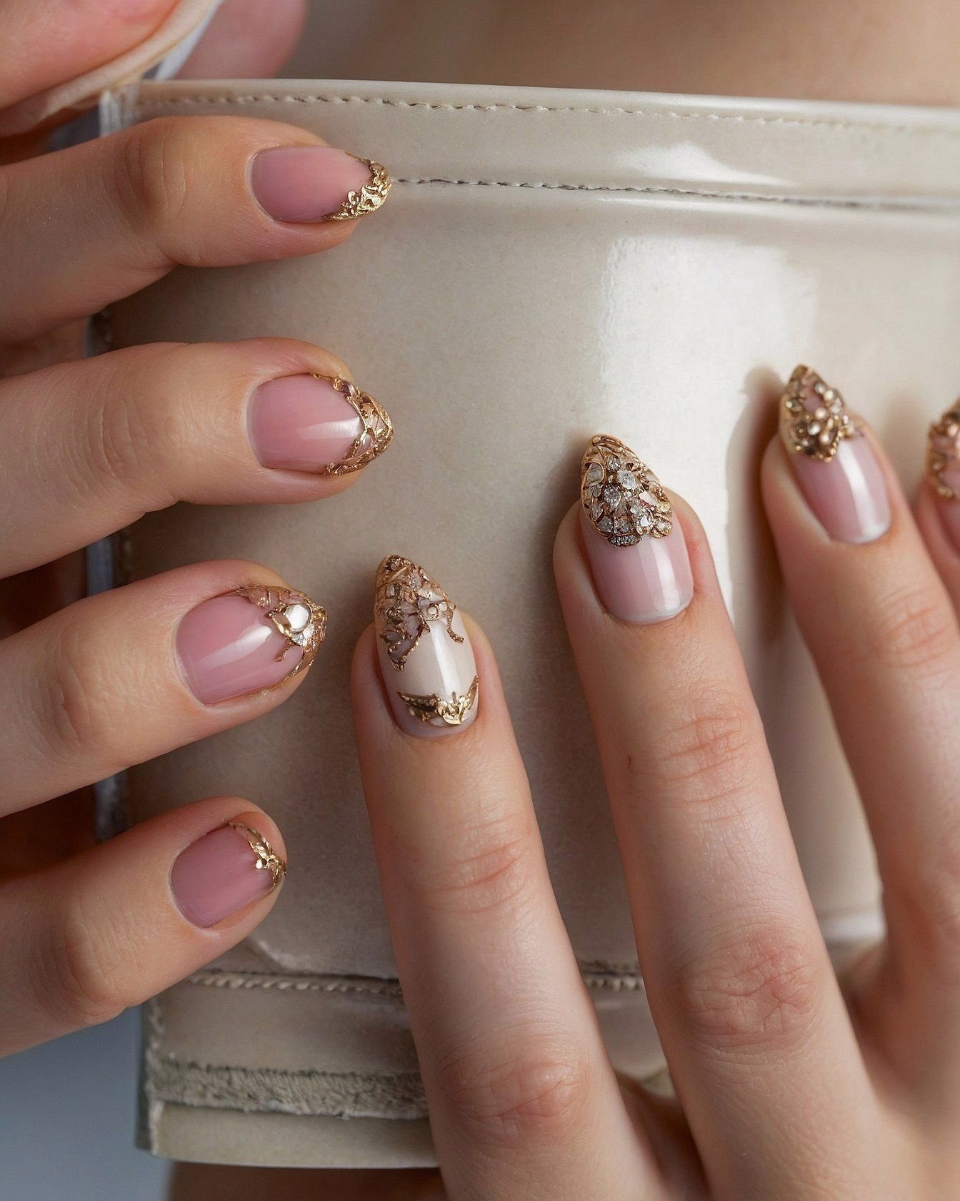 Soft pink nails with ornate gold accents