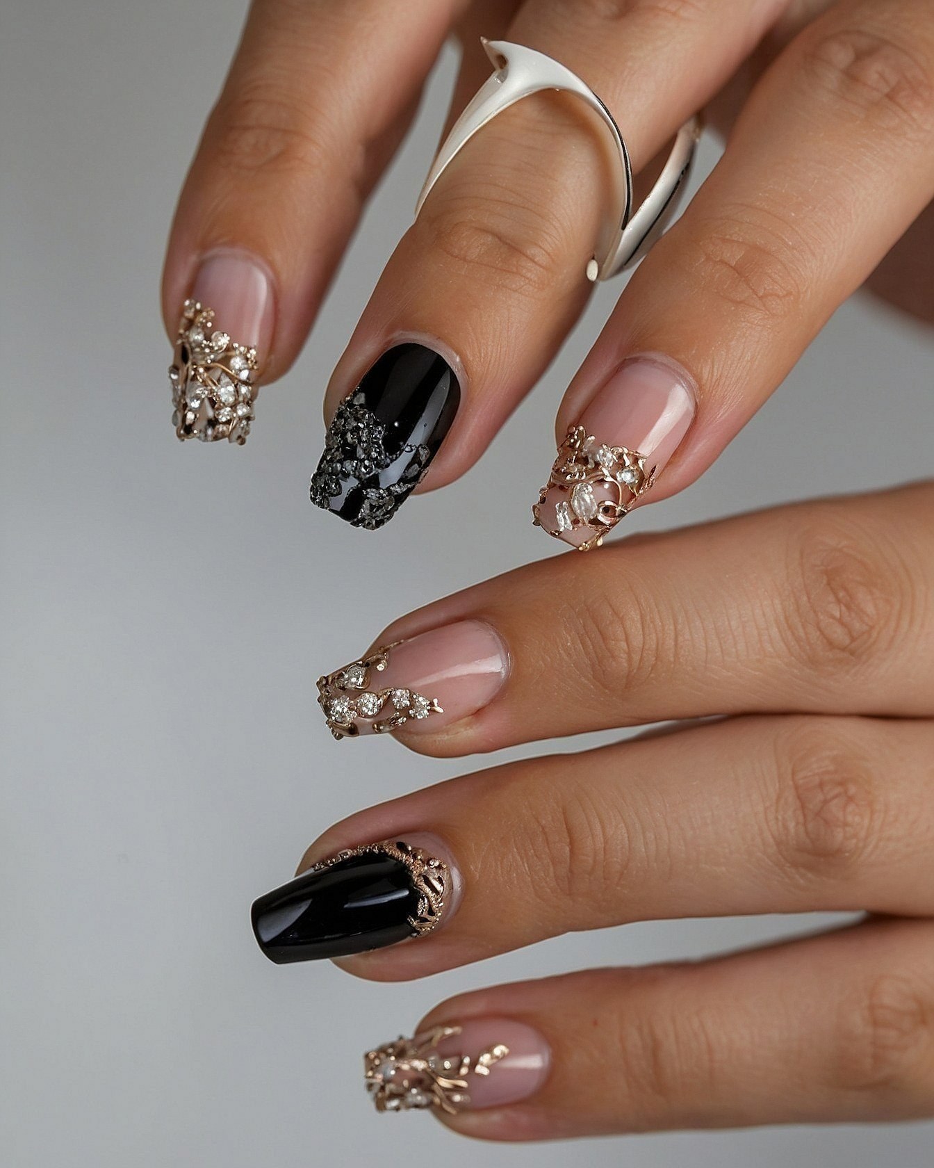 Nude and Black Nails with Intricate Gold Embellishments