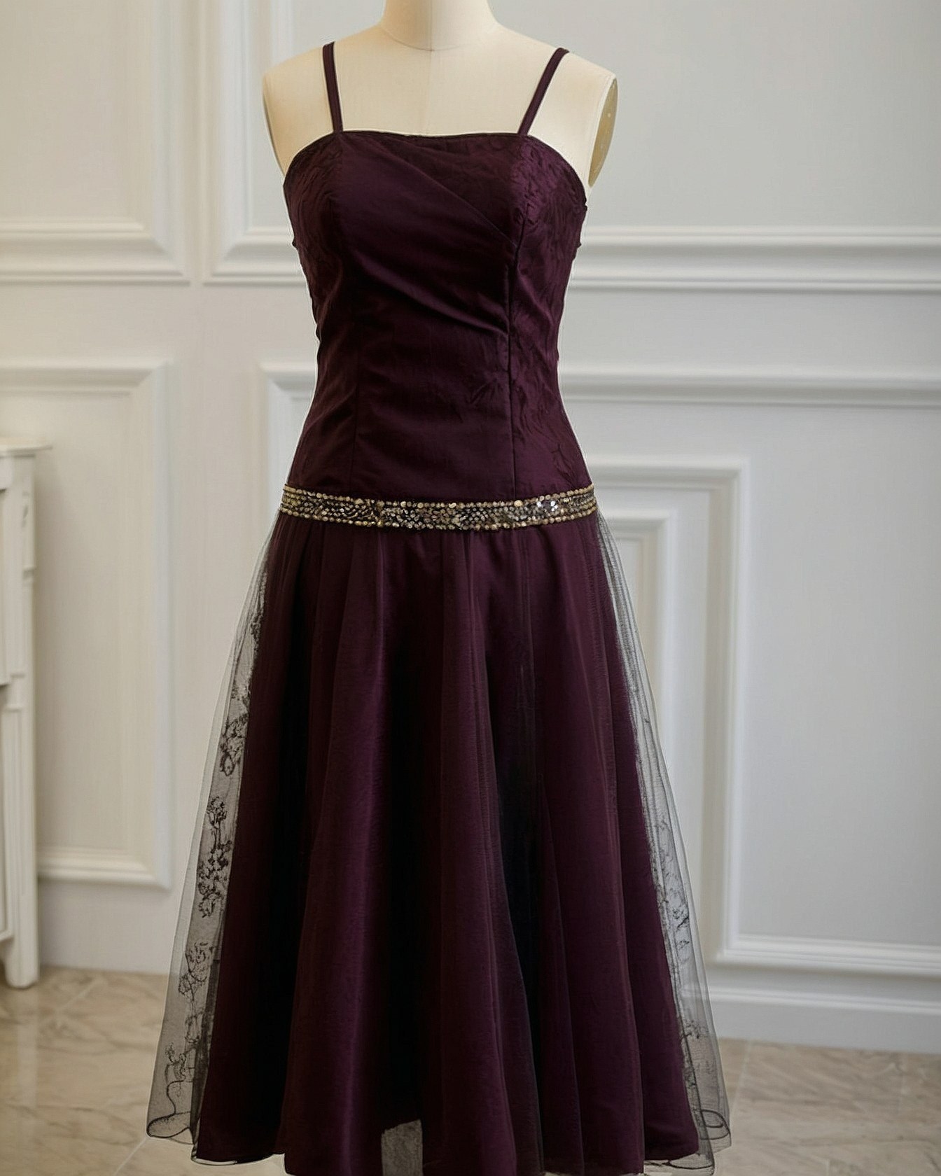 A dark plum dress with a beaded gold band