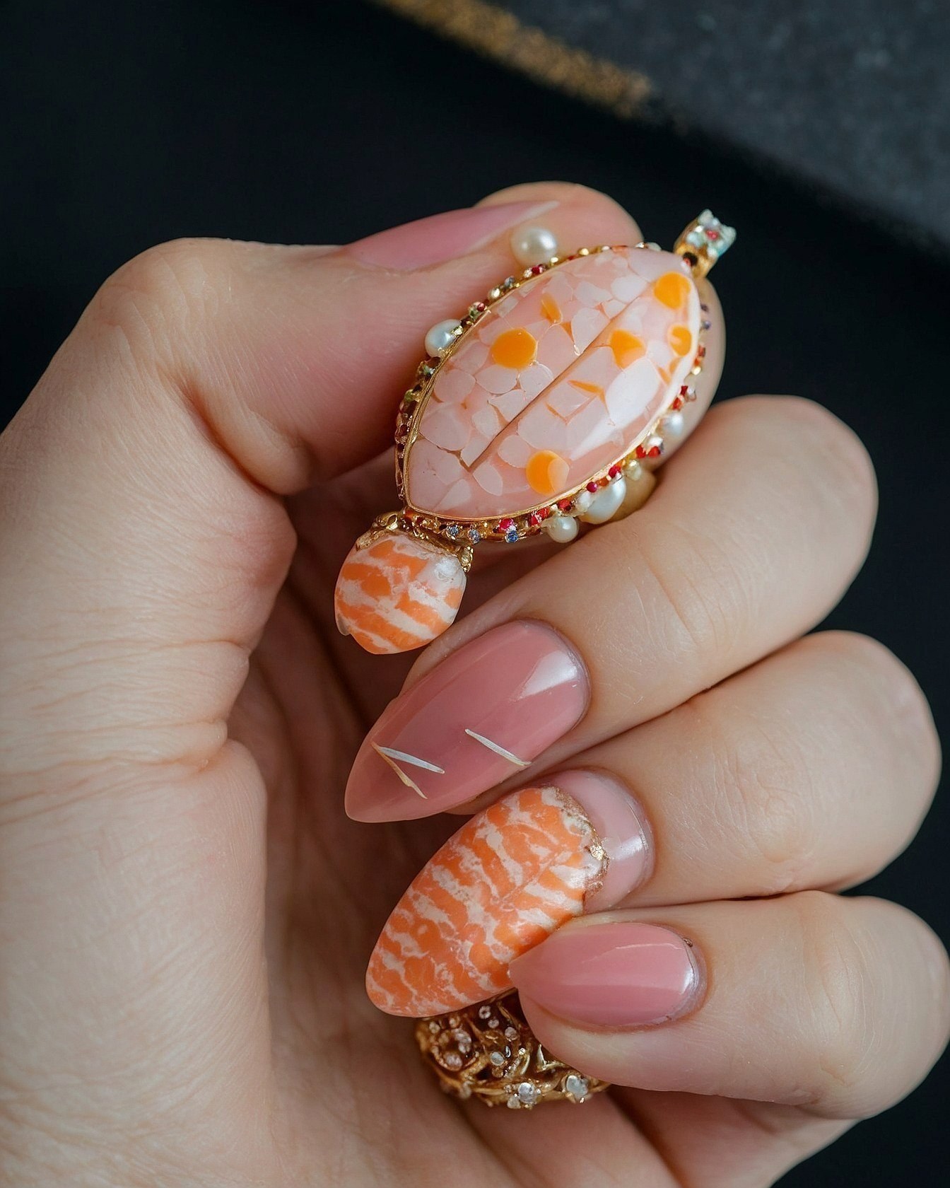 Close-up of Coral-Inspired Nails and Brooch Detail