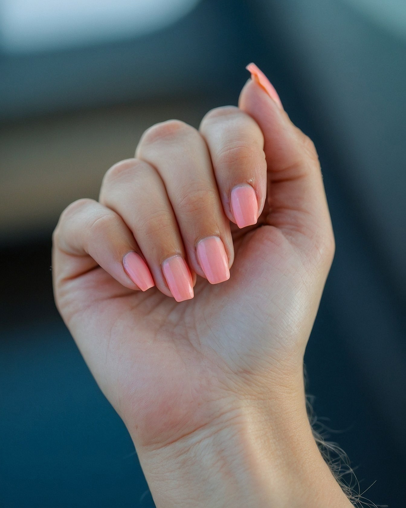 Close-up of a hand with coral-pink coffin nails