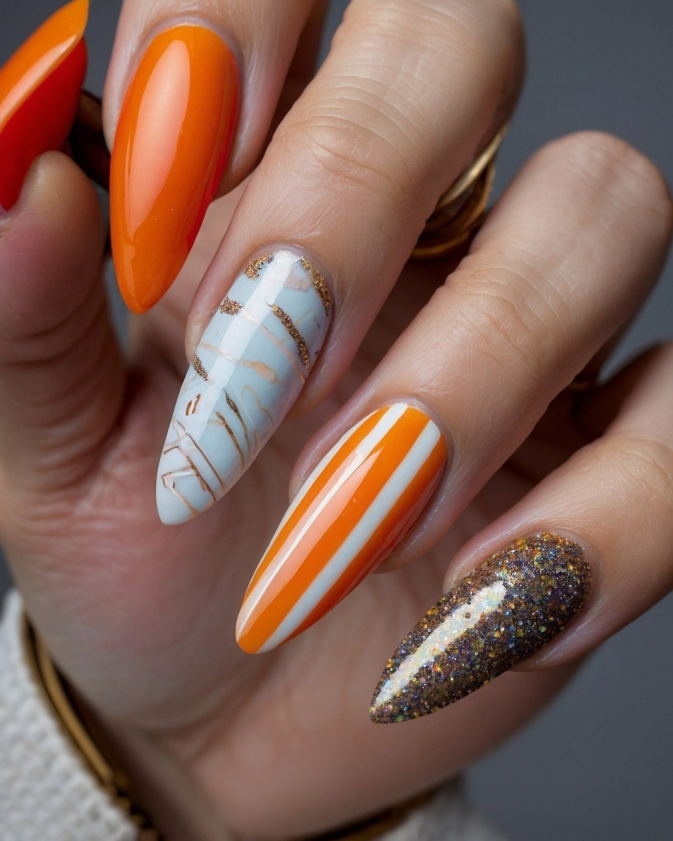 Orange and White Striped Almond Nails with Gold Accents