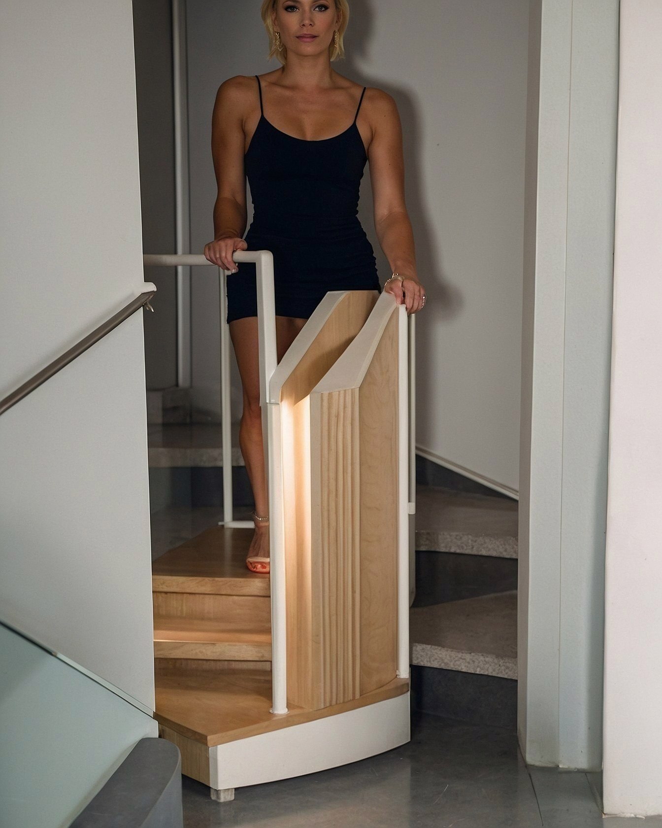 Charcoal mini dress beside pale maple stairs and ivory railings