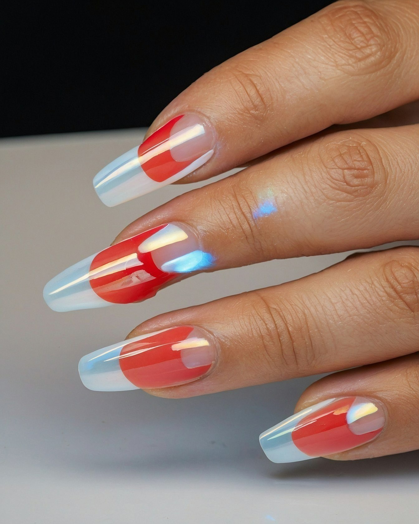 Graphic red and iridescent opal-toned coffin nails