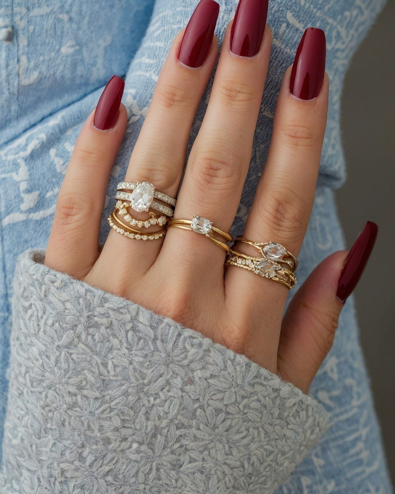 Close-up of Deep Burgundy Nails and Gold Rings
