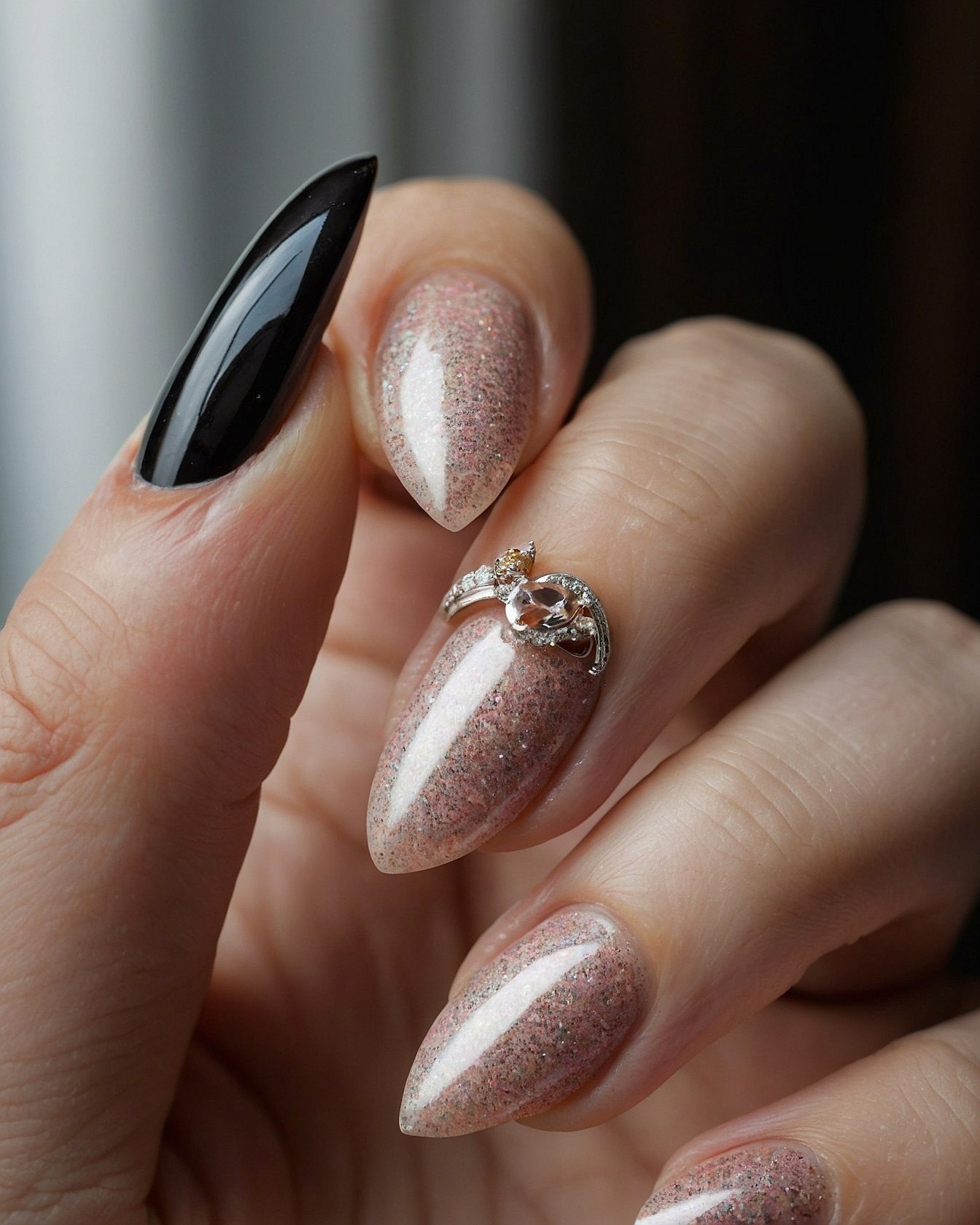 Close-up of Black and Shimmering Rose Almond Nails