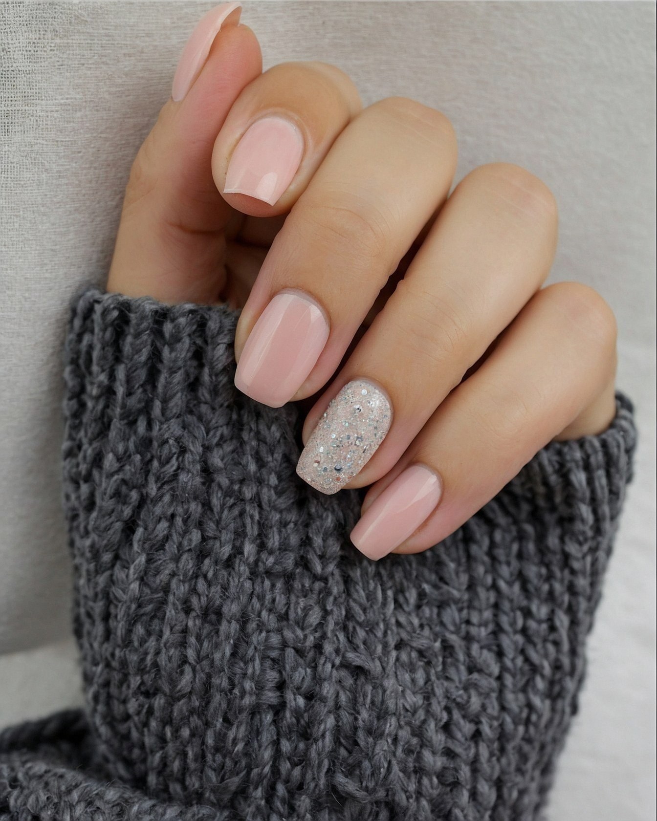 Close-up of hand with soft pink and glitter nails