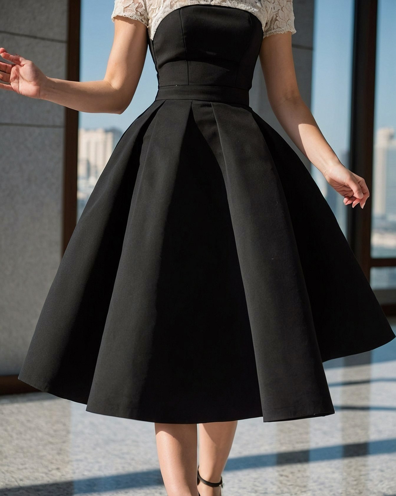 A black midi dress with lace accents and a full skirt