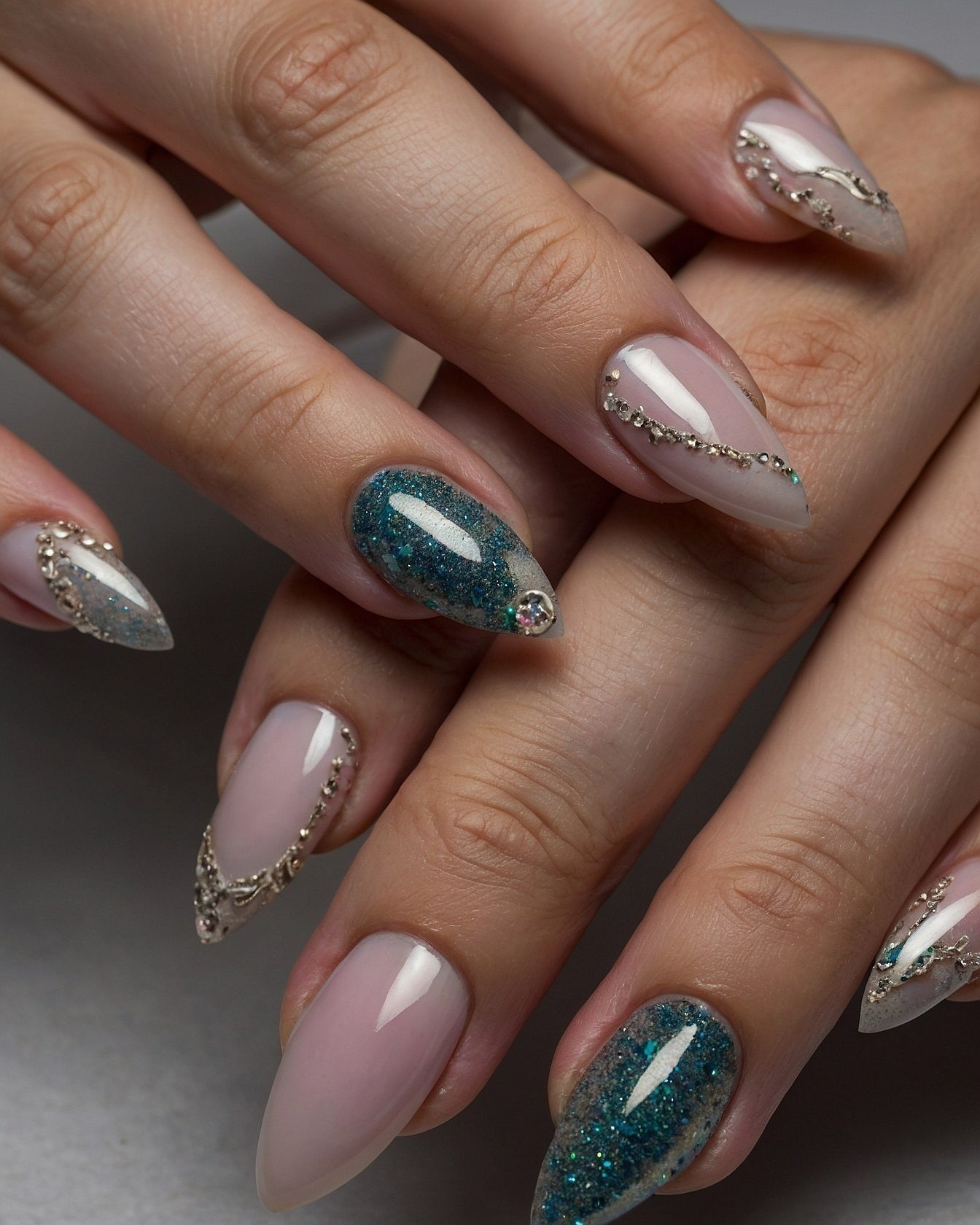 Stiletto nails with teal glitter and gold filigree