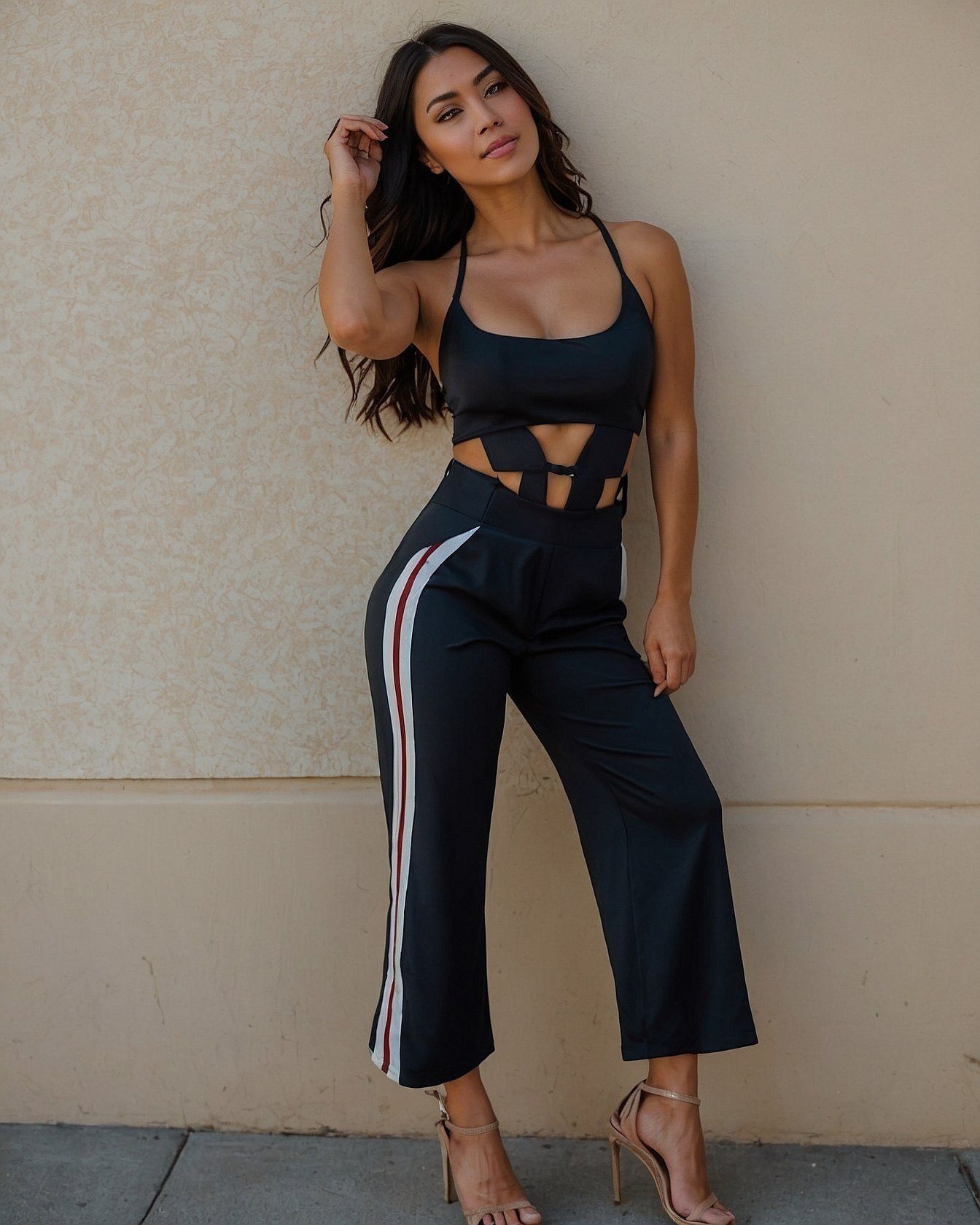 Sleek black cutouts and striped culottes against a warm beige wall