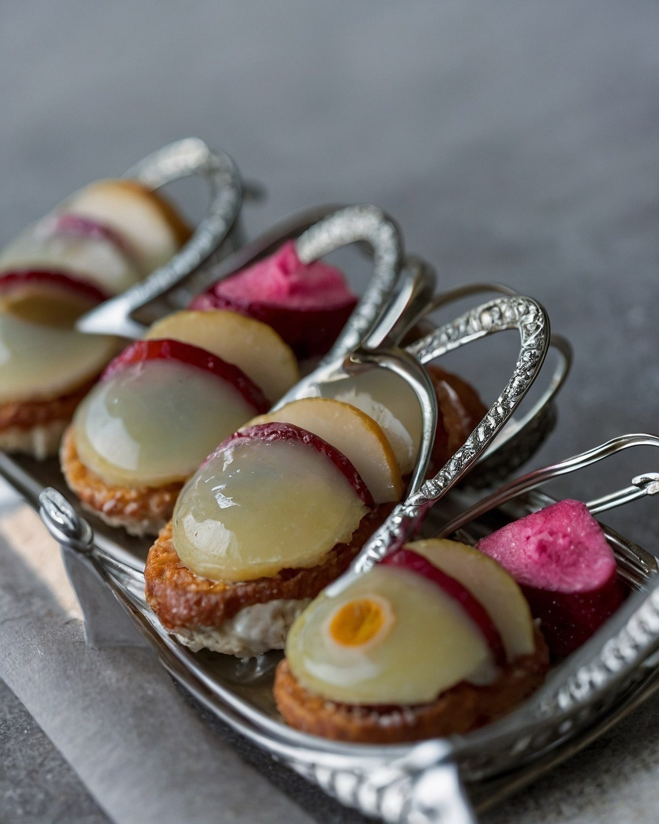 Ornate Silverware Holding Delicate Petite Fours