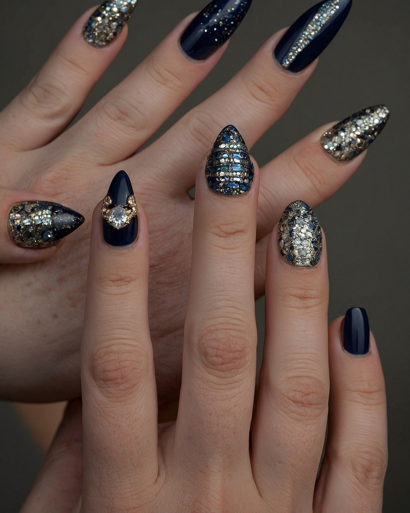 Close-up of Hands Adorned with Rich Blue and Gold Rhinestone Nails