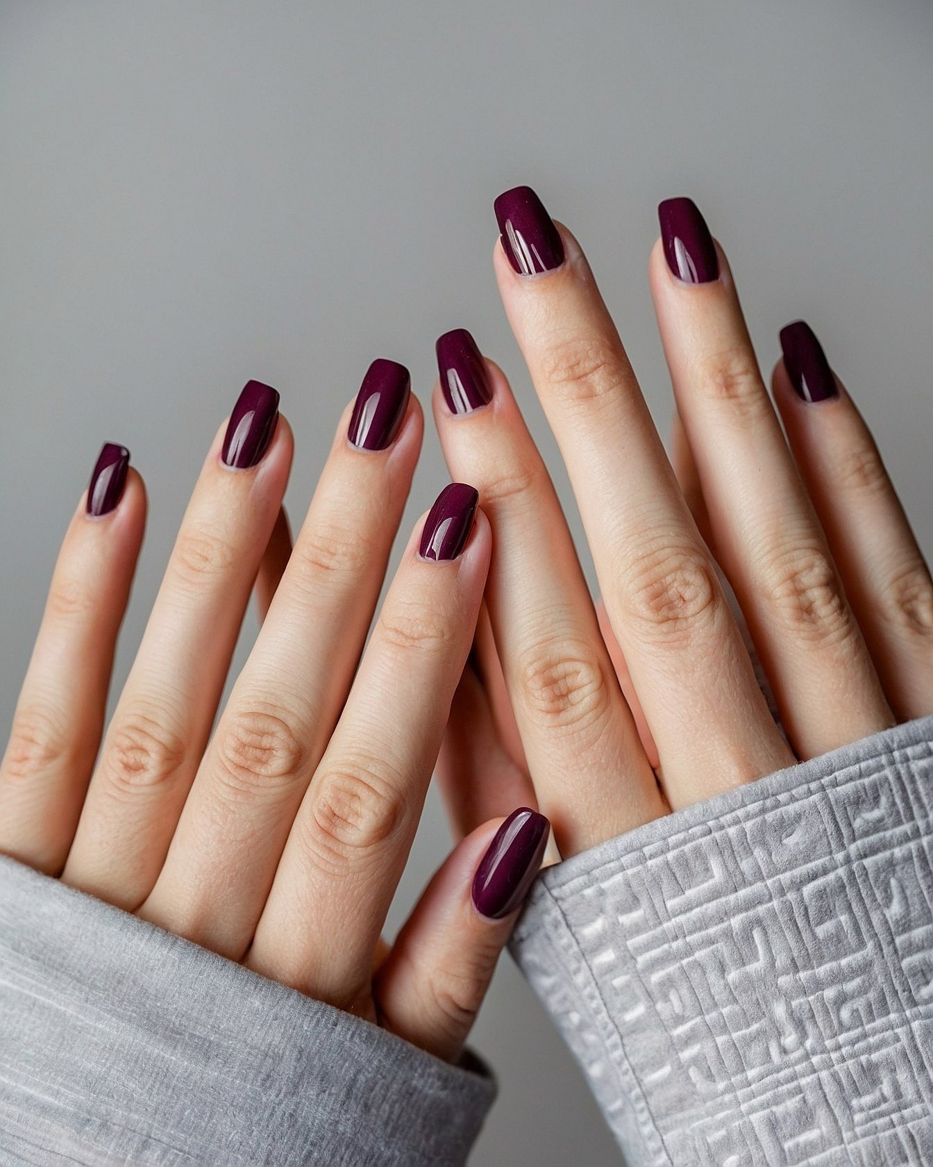 Dark Plum Square Nails Against Textured Grey
