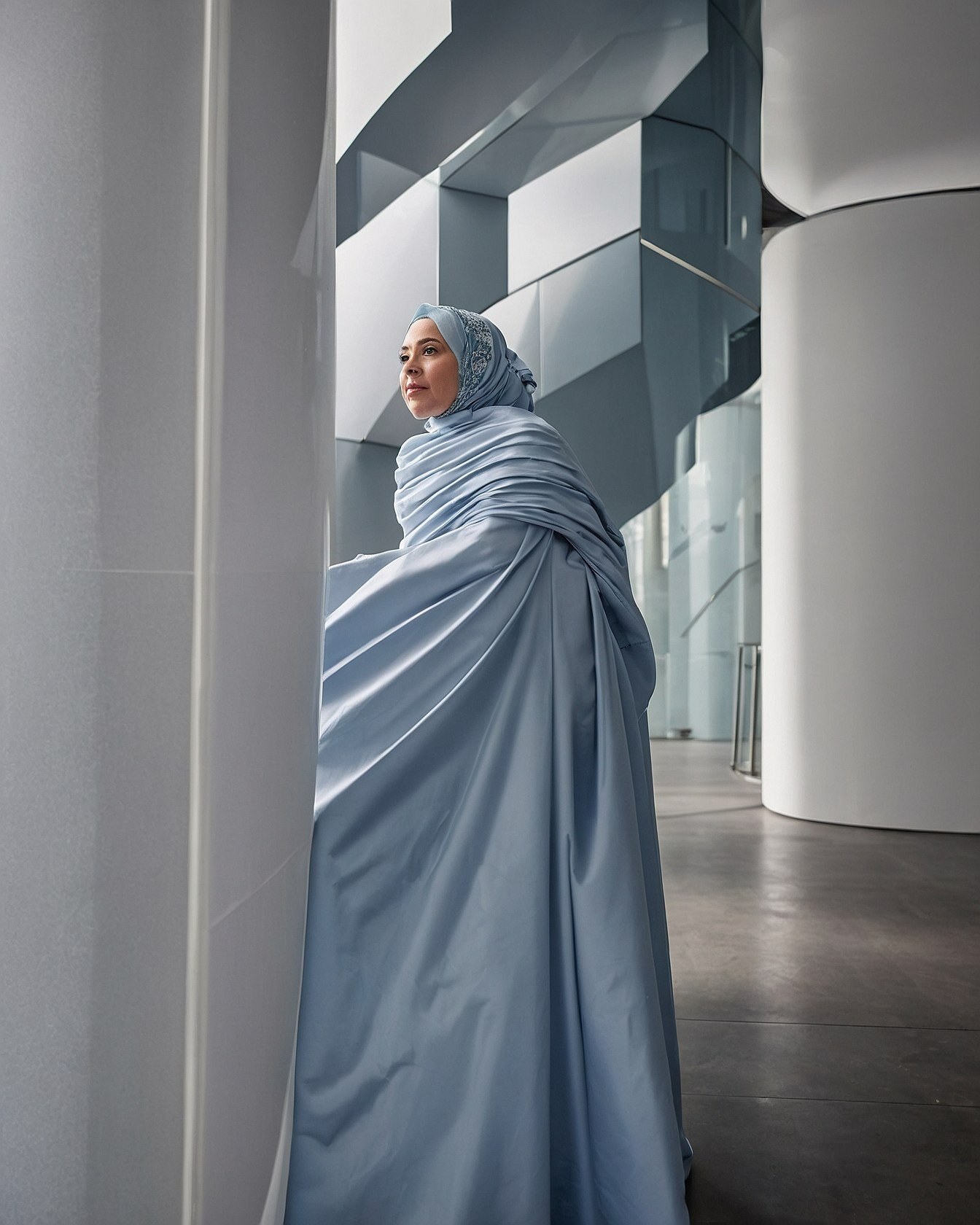 Flowing Light Blue Ensemble Against Geometric Architecture